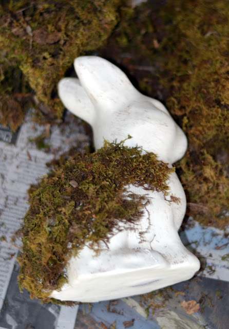 putting moss on a plain bunny figurine putting moss on a plain bunny figurine