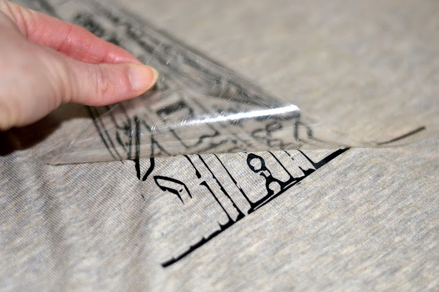 peeling the heat transfer vinyl from a cut image HTV image on t-shirt
